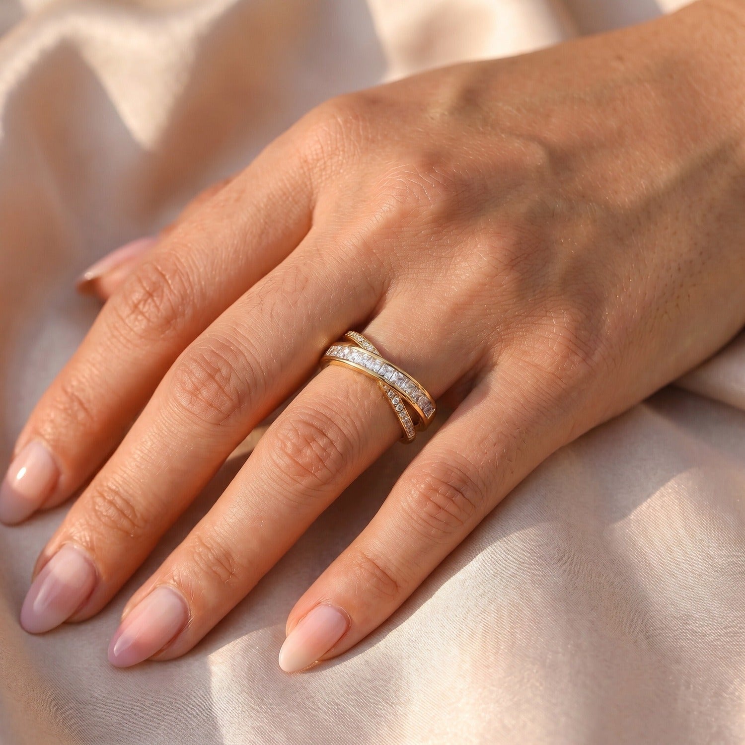 Cassia Ring in Gold am Ringfinger getragen, zweireihiger Statement-Ring auf Satin