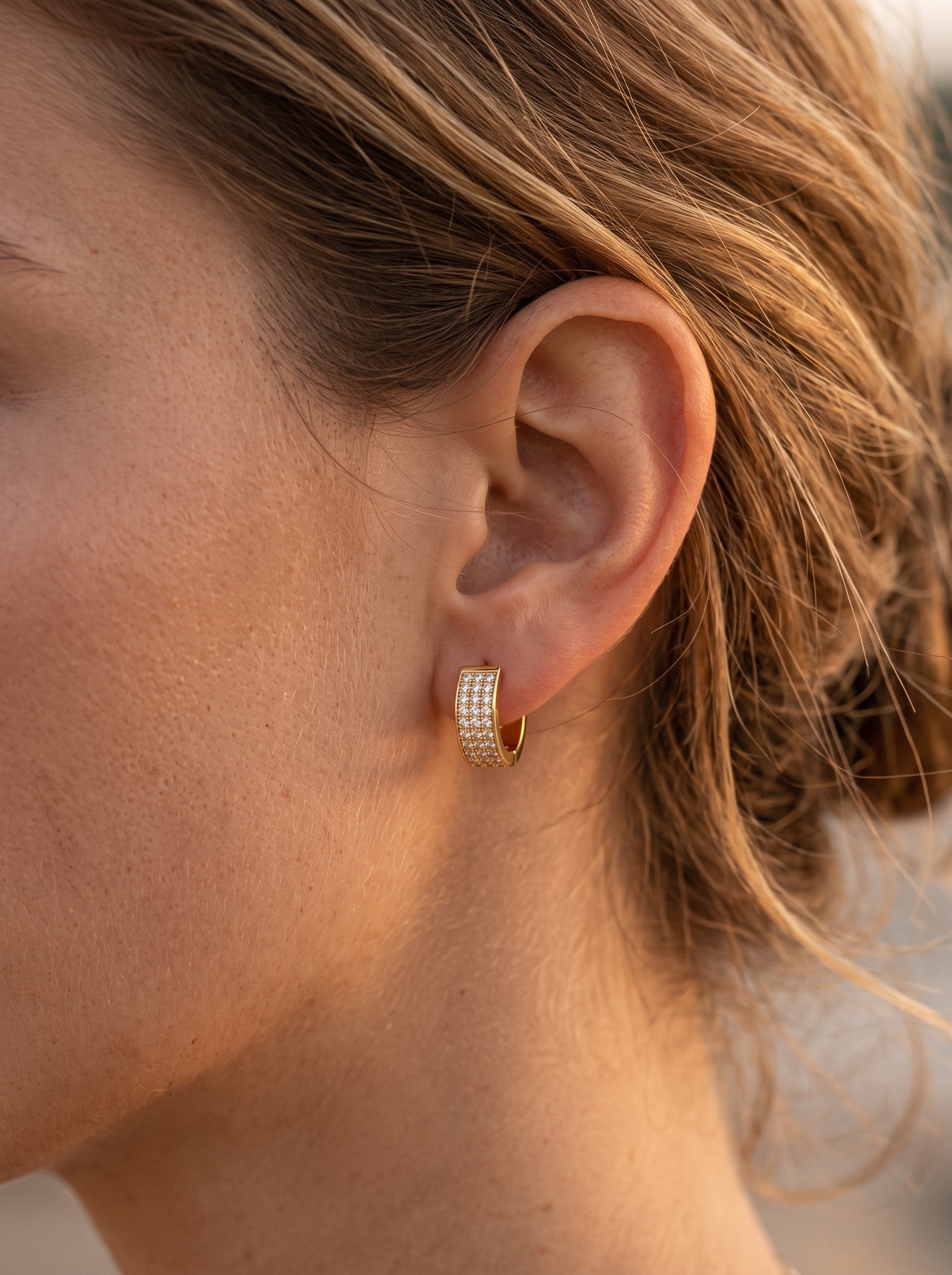 Minaz Ohrringe Soraya aus Edelstahl in Gold mit Zirkonia-Pavé, getragen am Ohrläppchen