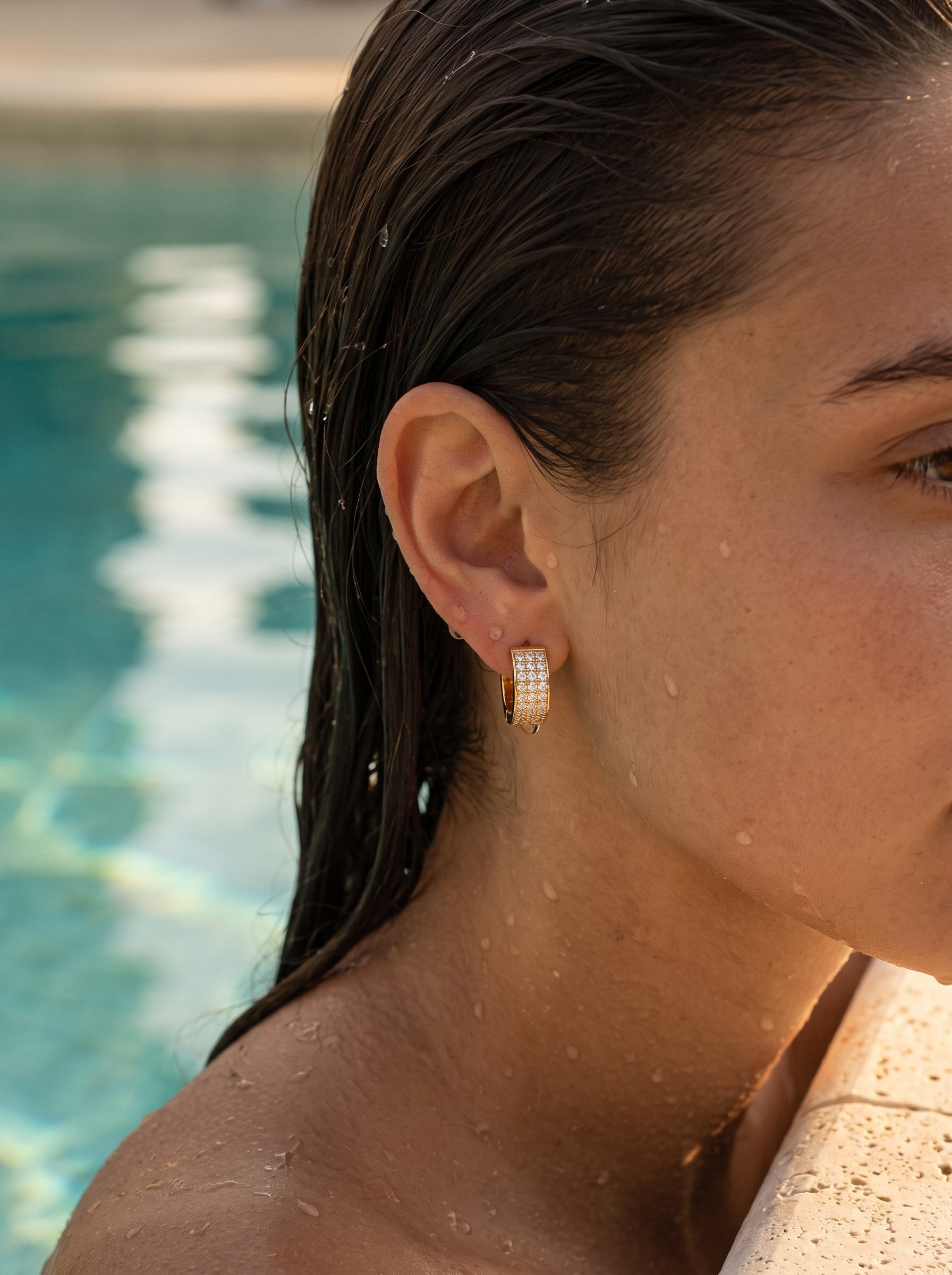 Minaz Ohrringe Soraya aus Edelstahl in Gold mit Zirkonia-Pavé, wasserfest am Pool bei Golden Hour