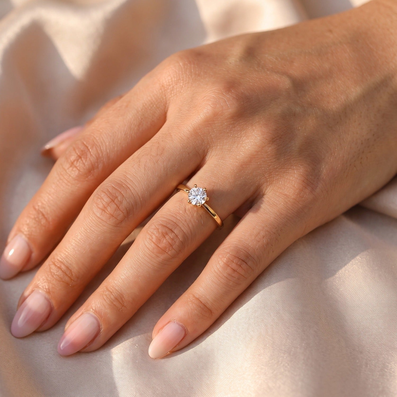 Zirkonia-Ring "Nalani" in Gold — am Ringfinger mit Mandel-Nägeln in Pastell-Ombré